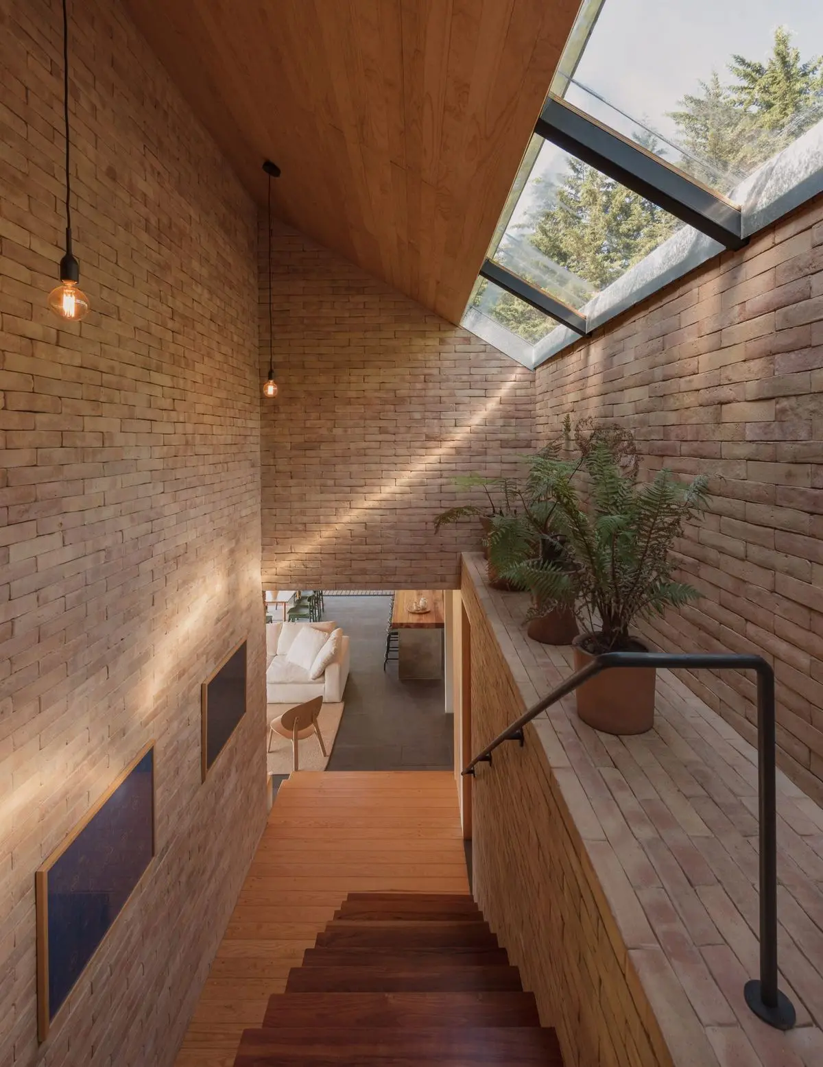 Interior residencial com paredes de tijolos ecológicos aparentes e iluminação zenital